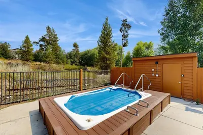 a hot tub sitting on a deck next to a fence at Hop Inn At Antlers Gulch in Keystone