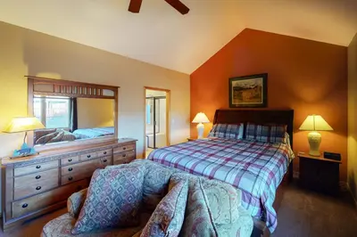 a bedroom with a bed and a mirror and a chair at Teller Townhomes 106 in Frisco