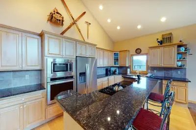a large kitchen with wooden cabinets and a granite counter top at Teller Townhomes 106 in Frisco