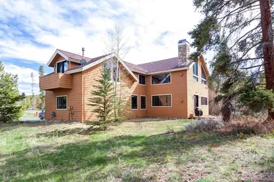 a large wooden house on a grass field at Western Wild Flower in Frisco