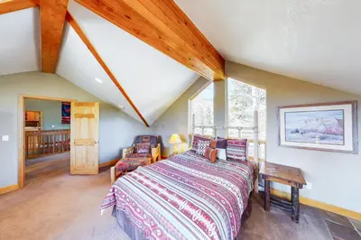 a bedroom with a bed and a large window at Western Wild Flower in Frisco