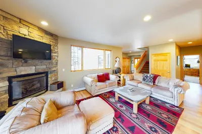 a living room with couches and a stone fireplace at Western Wild Flower in Frisco