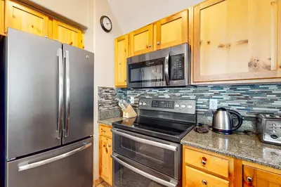 a kitchen with stainless steel appliances and wooden cabinets at Northstar Townhome Unit 1968 in Keystone
