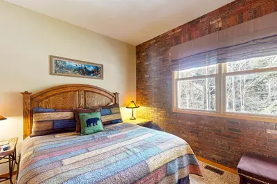 a bedroom with a bed and a brick wall at Northstar Townhome Unit 1968 in Keystone