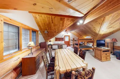 a room with a wooden ceiling with a table and chairs at Fairy Tale House in Dillon