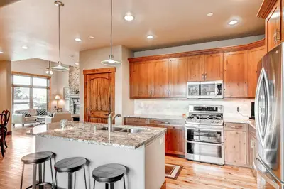 a kitchen with wooden cabinets and a island with bar stools at Bears Den Condo Unit 1 in Frisco