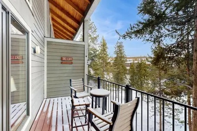 a porch with two chairs and a table at The Pines Condo Unit 2044 in Keystone