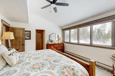 a bedroom with a bed with a ceiling fan and a window at The Pines Condo Unit 2044 in Keystone