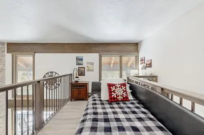 a room with a balcony with a bed and a table at The Pines Condo Unit 2044 in Keystone