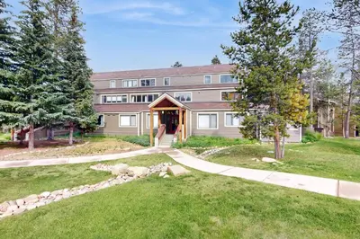 a large building with a pathway leading into a yard at The Pines Condo Unit 2044 in Keystone