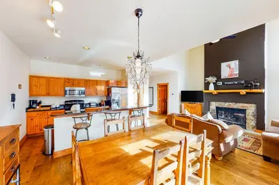 a kitchen and living room with a table and a fireplace at Water Dance Townhome 495 in Frisco