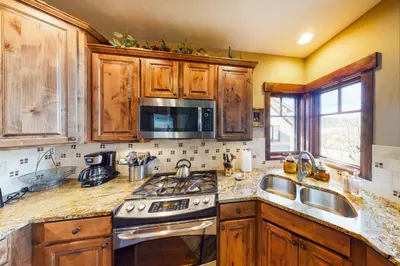 a kitchen with wooden cabinets and a stove and sink at Buffalo Lodge Townhomes 1293 in Silverthorne