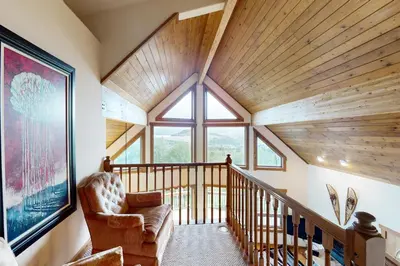 a room with a staircase with a chair and a large window at Ski Your Heart Out in Silverthorne