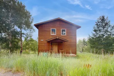 a small wooden house in a field of tall grass at Ski Your Heart Out in Silverthorne