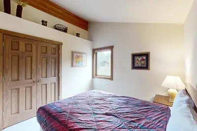 a bedroom with a bed and a door and a window at Ski Your Heart Out in Silverthorne