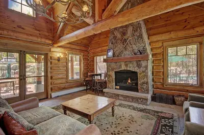 a living room with a fireplace in a log cabin at 6516 Settlers Creek condo in Snake River Health Services Incorporated Heliport