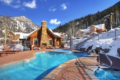 a swimming pool in front of a log cabin at 6516 Settlers Creek condo in Snake River Health Services Incorporated Heliport