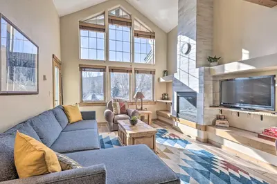 a living room with a blue couch and a tv at Frisco Condo with Balcony 7 Mi to Copper Mountain! in Frisco