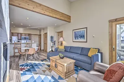 a living room with a blue couch and a table at Frisco Condo with Balcony 7 Mi to Copper Mountain! in Frisco