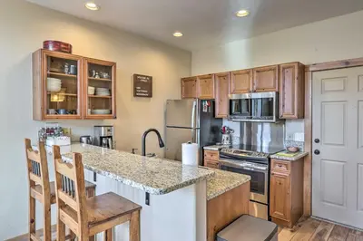 a kitchen with wooden cabinets and a counter top at Frisco Condo with Balcony 7 Mi to Copper Mountain! in Frisco