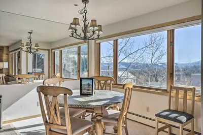 a dining room with a table and chairs and windows at Condo with Views and Hot Tub Access in Silverthorne! in Silverthorne