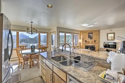 a kitchen with a sink and a dining room with a table at Condo with Views and Hot Tub Access in Silverthorne! in Silverthorne