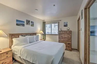 a bedroom with a large white bed and a window at Condo with Views and Hot Tub Access in Silverthorne! in Silverthorne