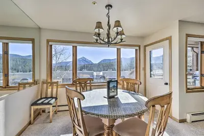 a dining room with a table and chairs and windows at Condo with Views and Hot Tub Access in Silverthorne! in Silverthorne