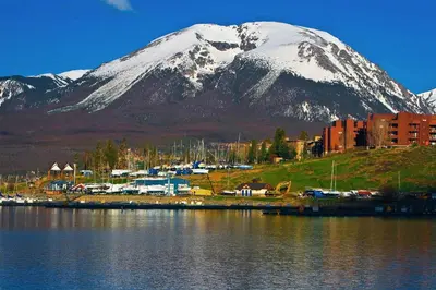 a snow covered mountain next to a body of water at Blue River Condo Unit 3301 in Silverthorne