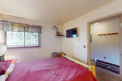 a bedroom with a large pink bed and a mirror at Watch Hill Condos Unit 614 in Silverthorne