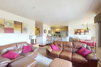 a living room with two brown leather couches and pink pillows at Watch Hill Condos Unit 614 in Silverthorne
