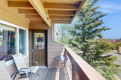 a porch with two chairs and a tree at Watch Hill Condos Unit 614 in Silverthorne