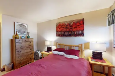 a bedroom with a red bed and a wooden dresser at Watch Hill Condos Unit 614 in Silverthorne
