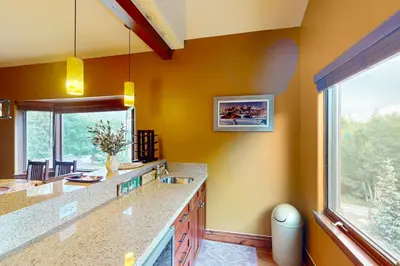 a kitchen with yellow walls and a large window at Marine Park Condo Unit C-16 in Frisco