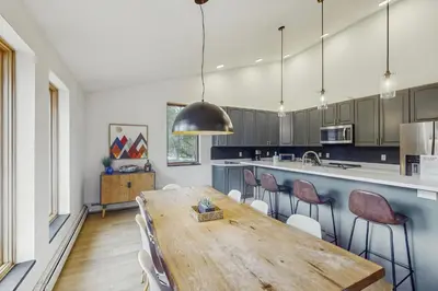 a large kitchen with a wooden table and chairs at Mountain Modern Escape in Fraser