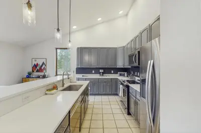 a kitchen with blue cabinets and white counter tops at Mountain Modern Escape in Fraser
