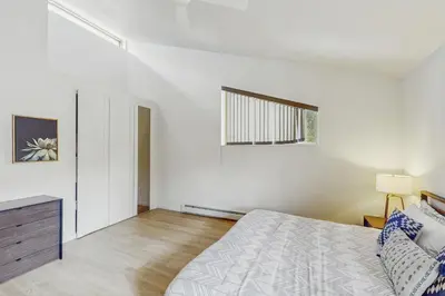 a white bedroom with a bed and a window at Mountain Modern Escape in Fraser