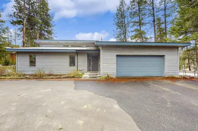 a white house with a garage and a driveway at Mountain Modern Escape in Fraser