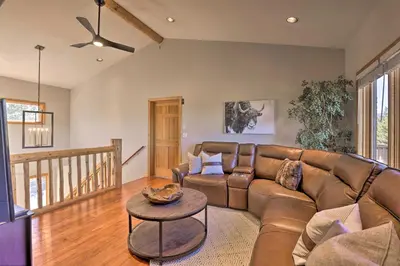 a living room with a leather couch and a table at 6 Mi to Keystone Ski! Mtn-View Cabin with Game Room in Silverthorne