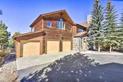 a house with two garage doors on a driveway at 6 Mi to Keystone Ski! Mtn-View Cabin with Game Room in Silverthorne