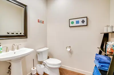a bathroom with a sink and a toilet and a mirror at Steps to Conquest Ski Lift Granby Home with Grill in Granby