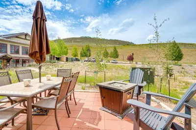 a patio with a table and chairs and an umbrella at Steps to Conquest Ski Lift Granby Home with Grill in Granby