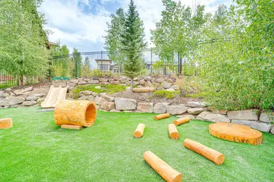 a backyard with a playground with logs on the grass at Steps to Conquest Ski Lift Granby Home with Grill in Granby