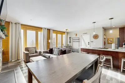 a kitchen and living room with a wooden table at Take the Mountain View in Silverthorne