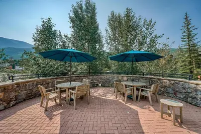 two tables and chairs with umbrellas on a patio at Buffalo Lodge 2 Bed 2 Ba BLCD2 in Keystone