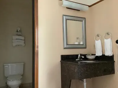 a bathroom with a sink and a toilet and a mirror at Luxury Inn & Suites in Silverthorne