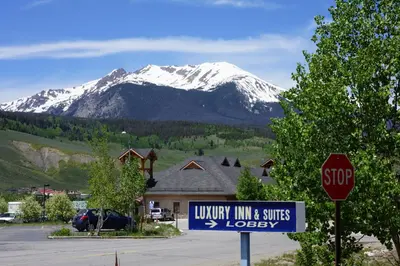 a stop sign in front of a house with a snow covered mountain at Luxury Inn & Suites in Silverthorne