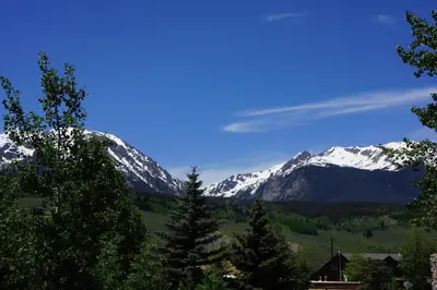a view of a snowy mountain range with trees at Luxury Inn & Suites in Silverthorne