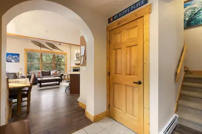a hallway with a wooden door and a living room at 8767 Trappers Crossing condo in Keystone
