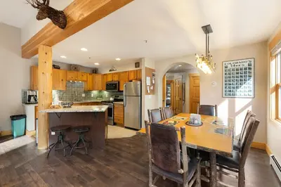 a kitchen and dining room with a wooden table and chairs at 8767 Trappers Crossing condo in Keystone